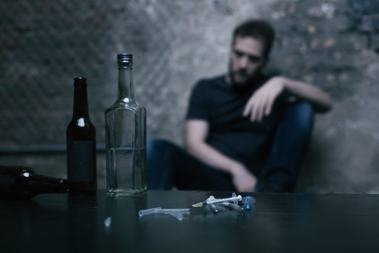 Alcohol in bottles and used syringes lying on the table